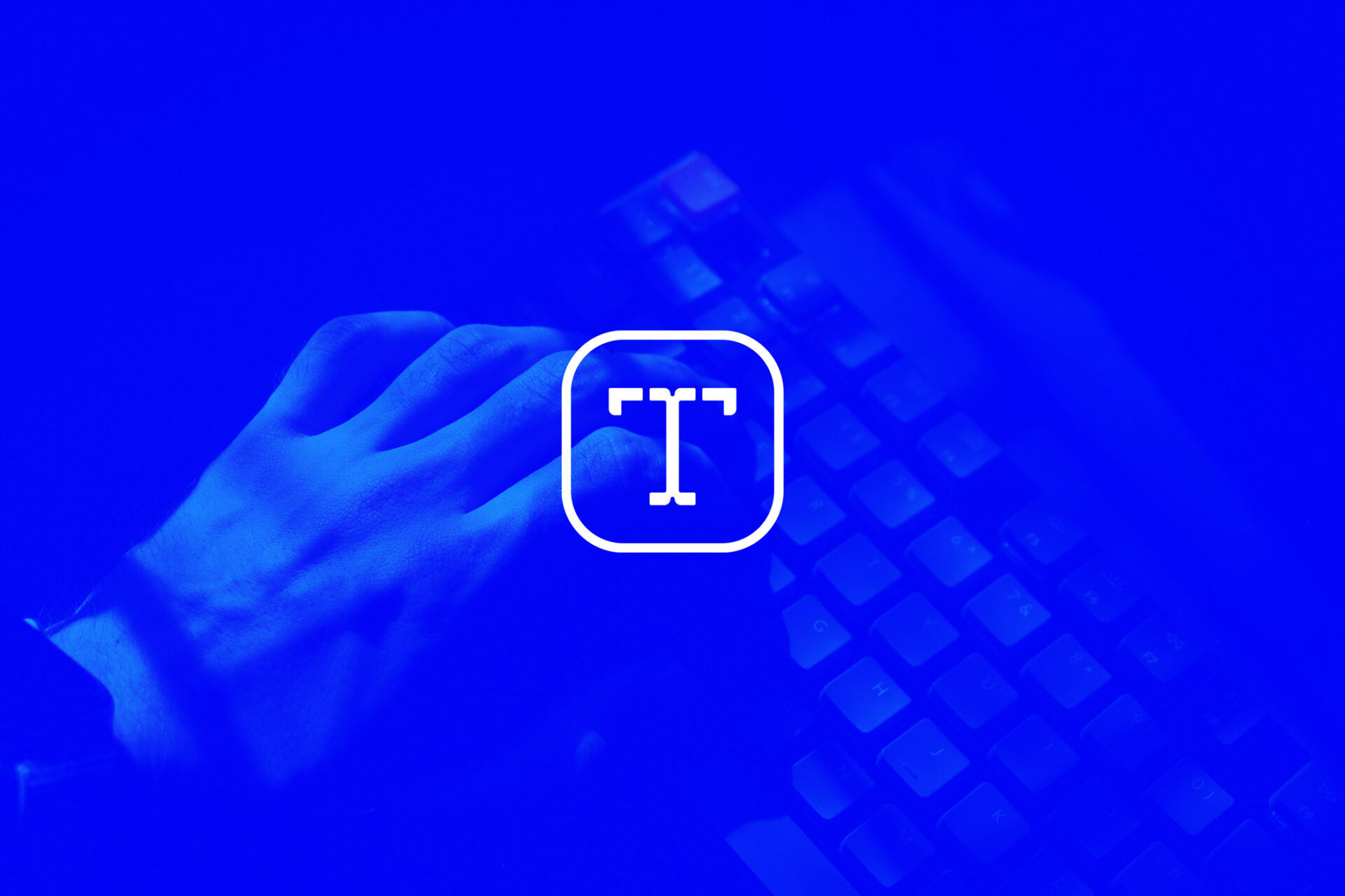 Weißes Transkript.at Icon-Logo auf blauem Foto mit Hand und Tastatur im Hintergrund.
