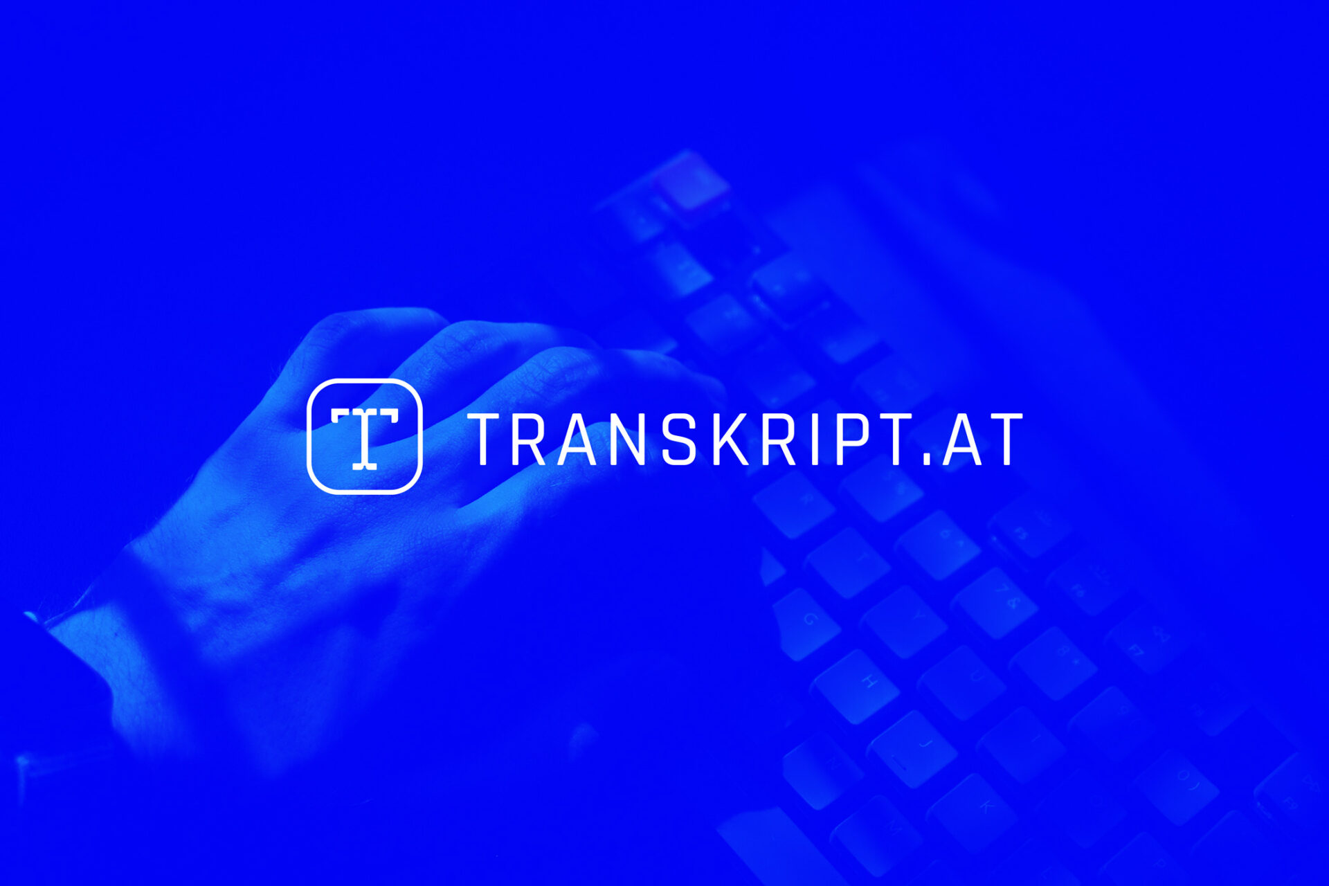 Weißes Transkript.at Logo auf blauem Foto mit Hand und Tastatur im Hintergrund.