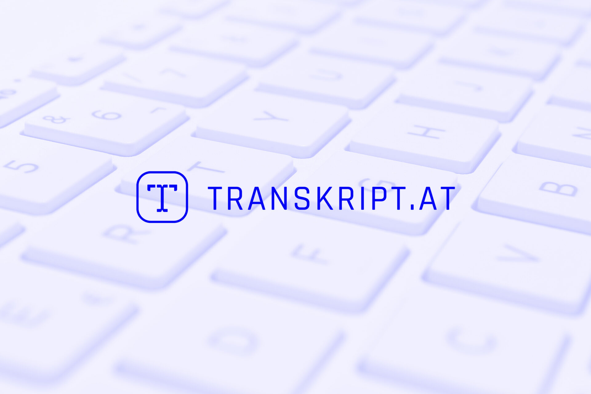 Blauer transkript.at Logo-Schriftzug mit Icon auf weißer Computertastatur im Hintergrund.